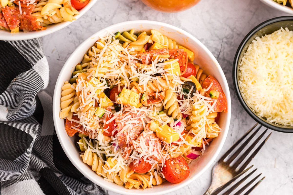 a bowl of Italian pasta salad with parmesan cheese on top