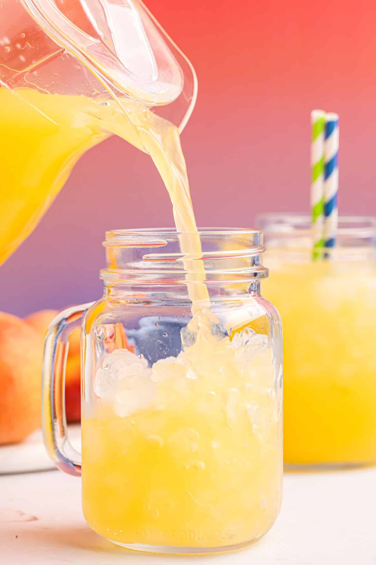 pouring a glass of peach lemonade