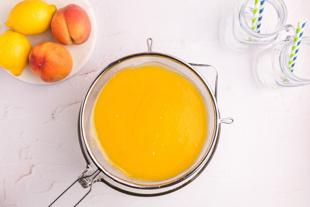 peach puree in a strainer