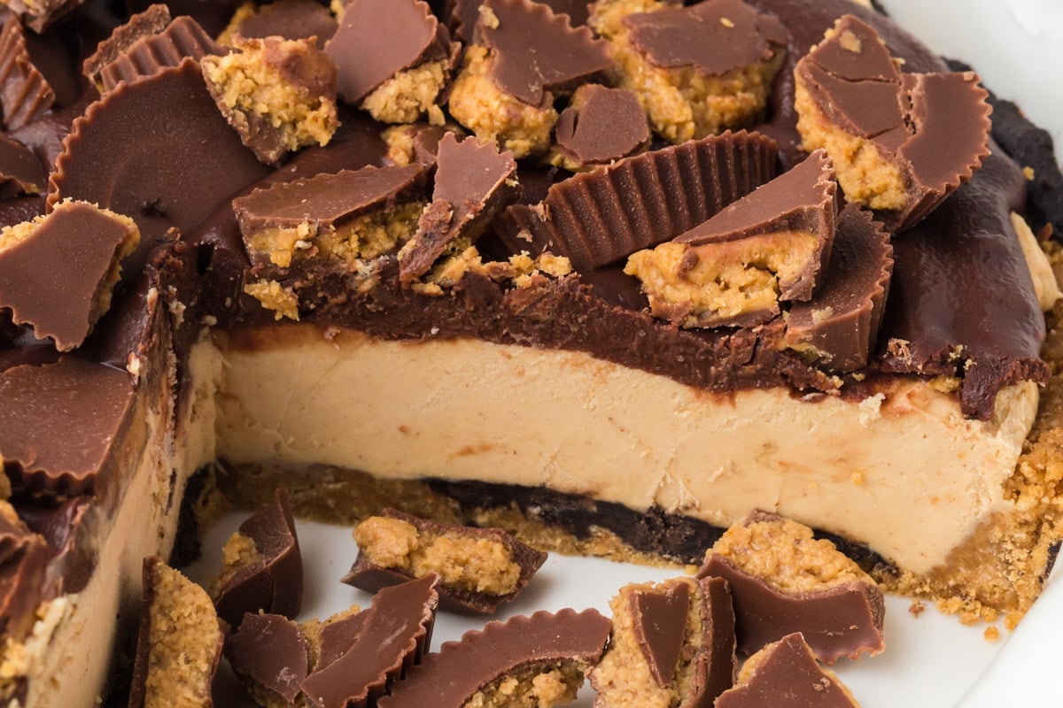 closeup of a chocolate peanut butter pie with reese's cups on top
