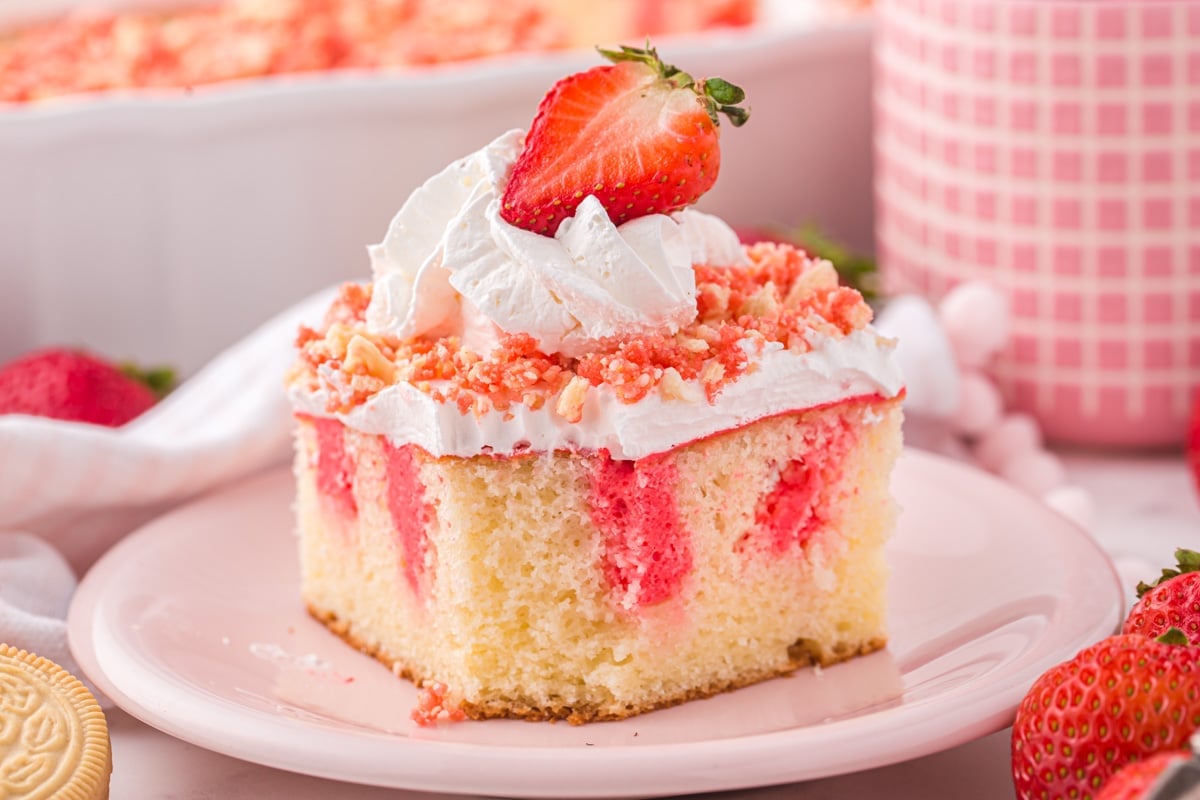 a piece of strawberry crunch poke cake on a plate