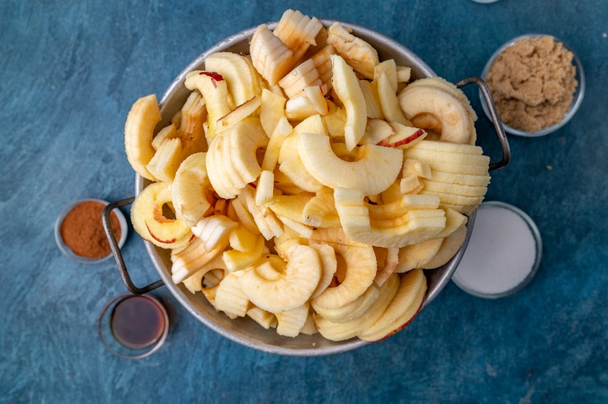 peeled & sliced apples in a colander on a table
