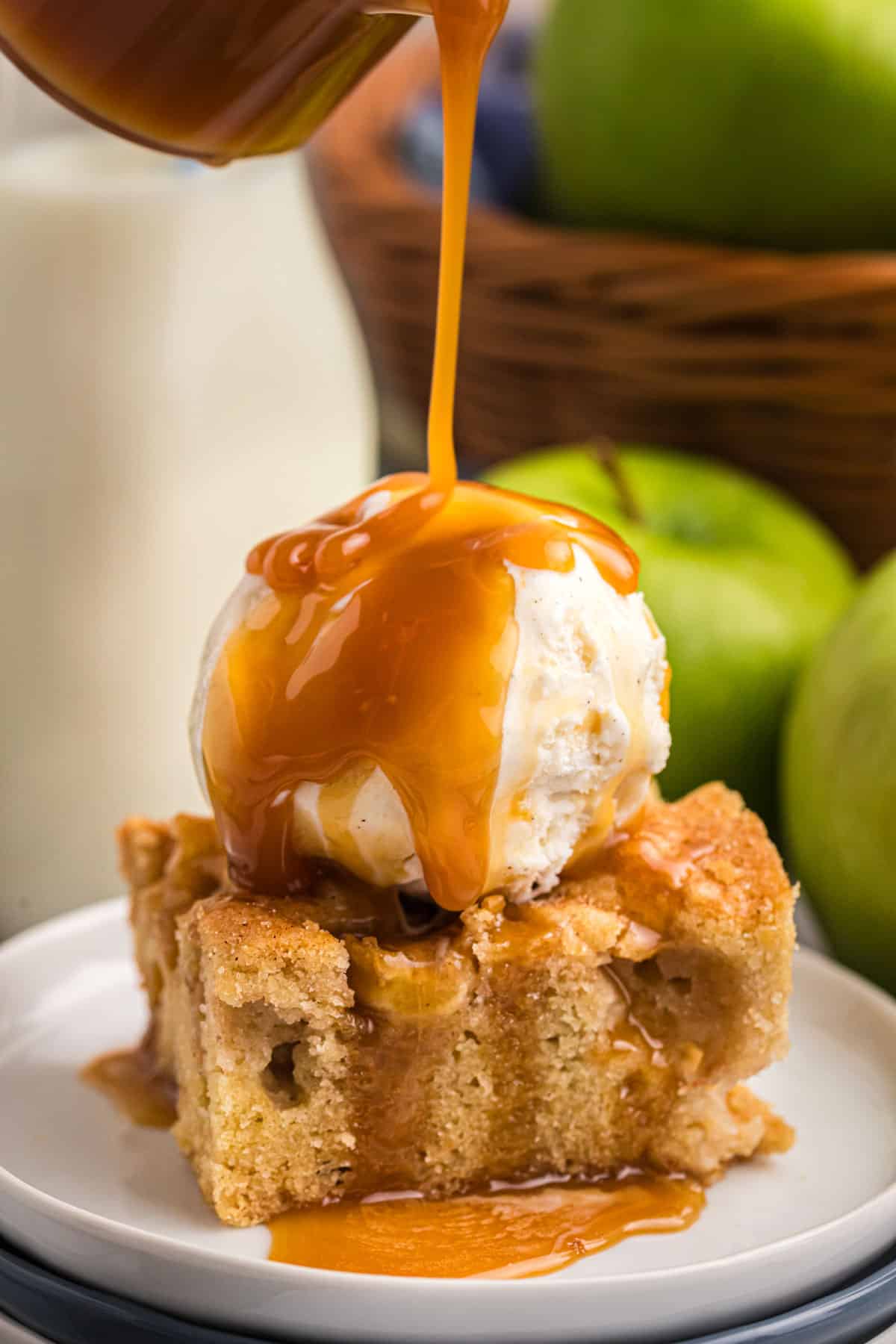 caramel pouring over apple cake with ice cream