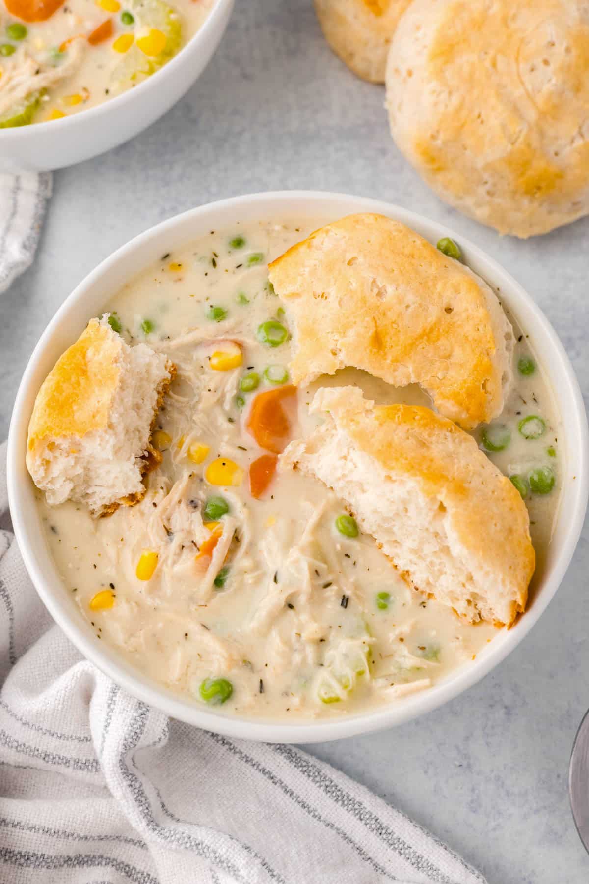 a bowl of chicken pot pie soup with biscuits