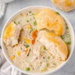 a bowl of chicken pot pie soup with biscuits