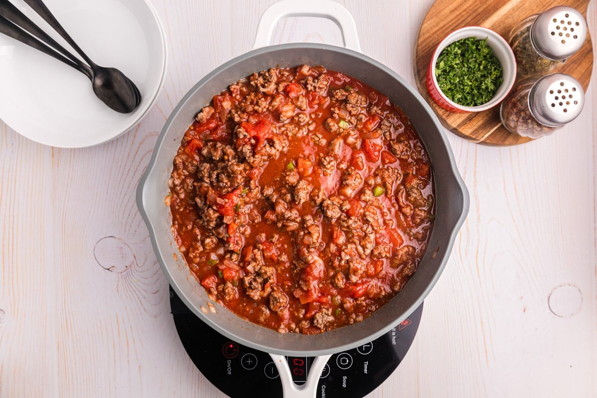 ground beef and tomatoes mixed in a skillet