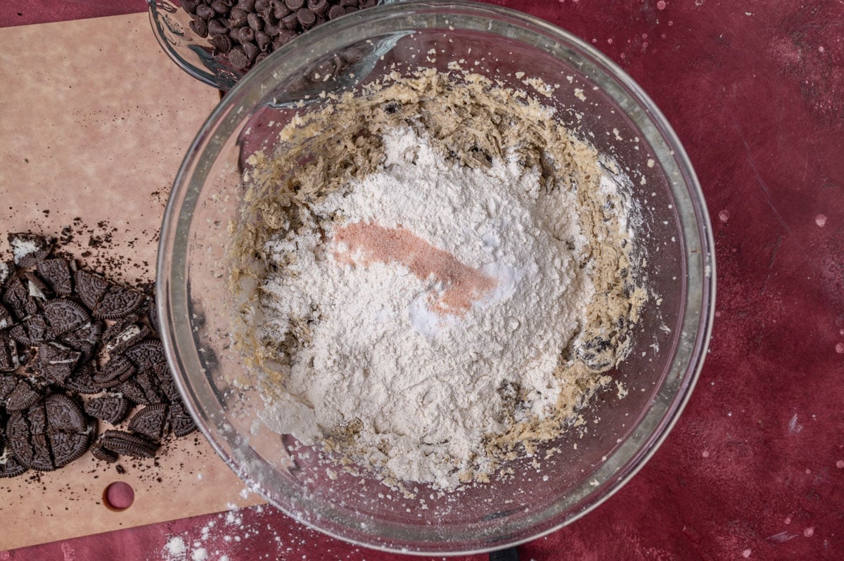 dry ingredients for cookies over wet ingredients in a glass bowl