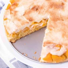 peaches and cream cake with a slice out of it