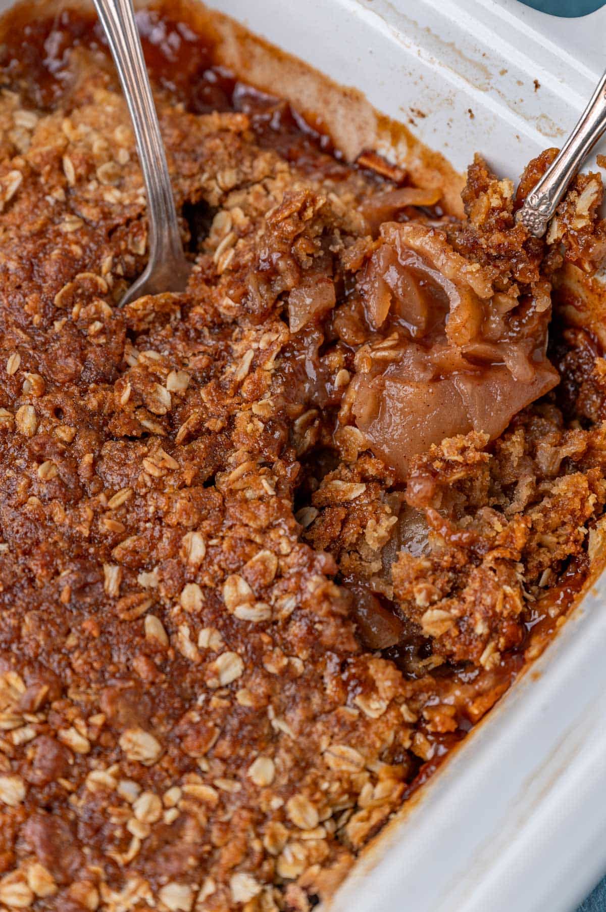 apple crisp in a slow cooker with two spoons