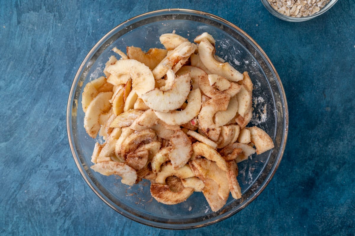 sliced apples tossed with cinnamon and sugar in a bowl