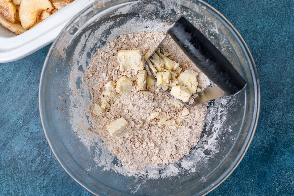 pastry cutter cutting butter into an oat sugar mixture