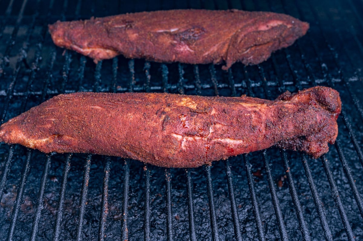 two pork tenderloins on a smoker grill