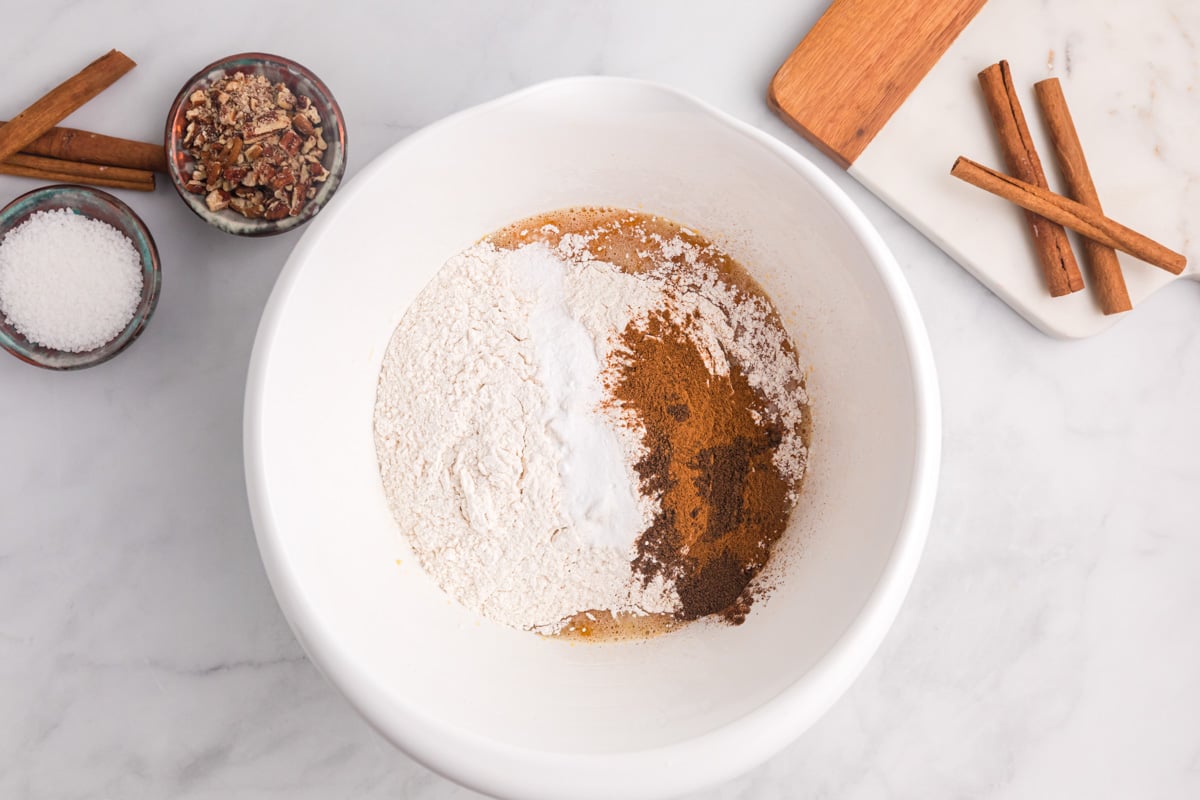 dry ingredients for sweet potato bread over wet ingredients in a bowl