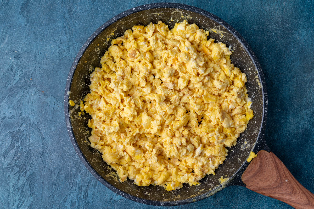 a skillet with creamy scrambled eggs in it