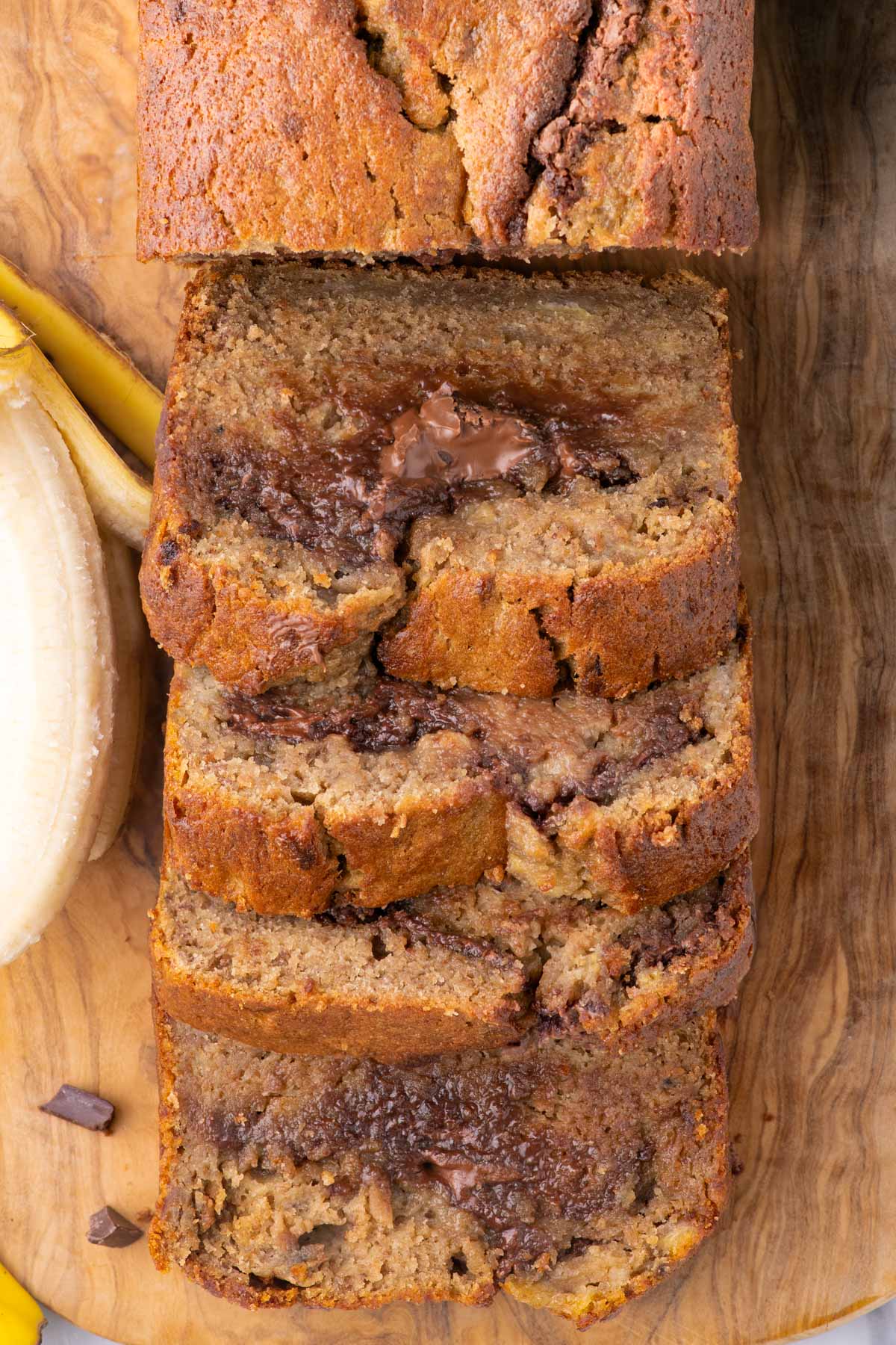 a sliced loaf of buttermilk banana bread with chocolate inside