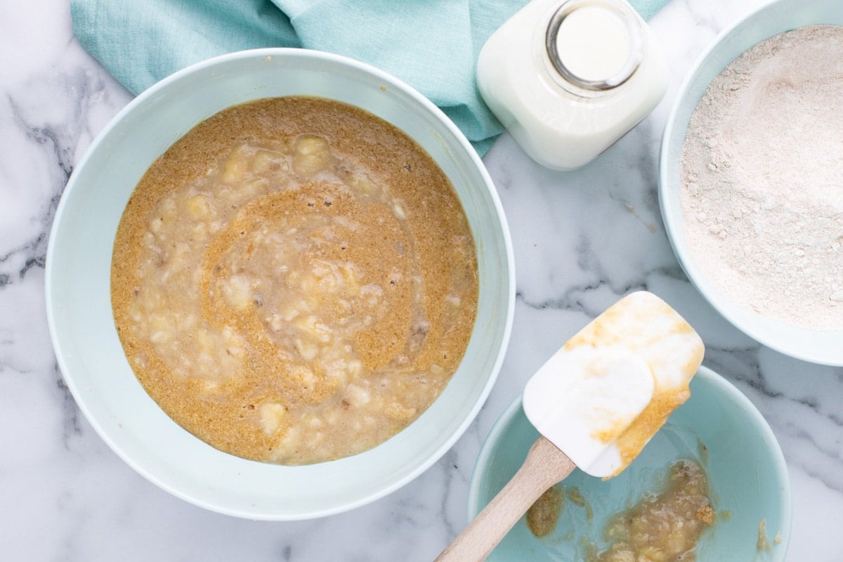 banana bread batter with mashed bananas mixing in