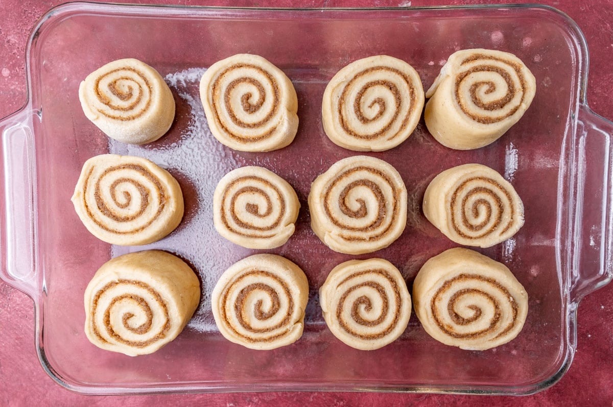 unbaked cinnamon rolls in a glass pan