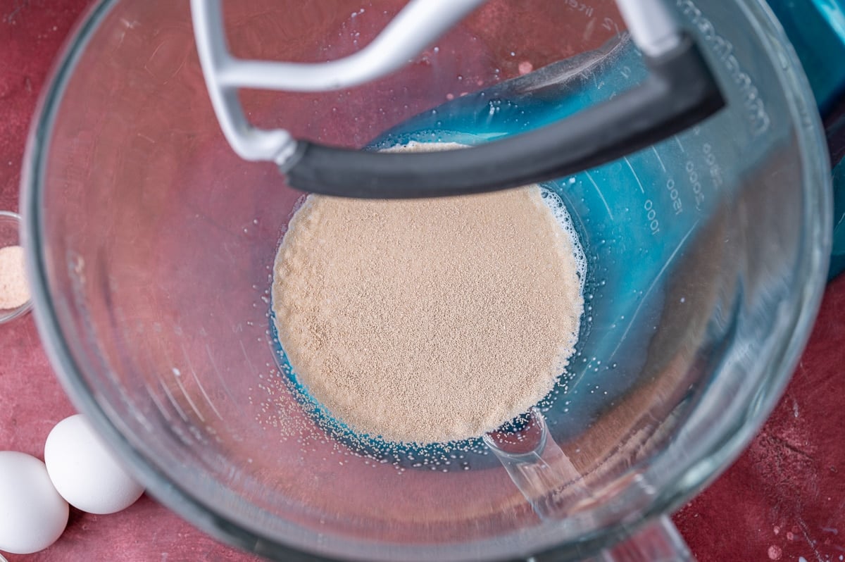 milk with yeast over it in a glass mixing bowl