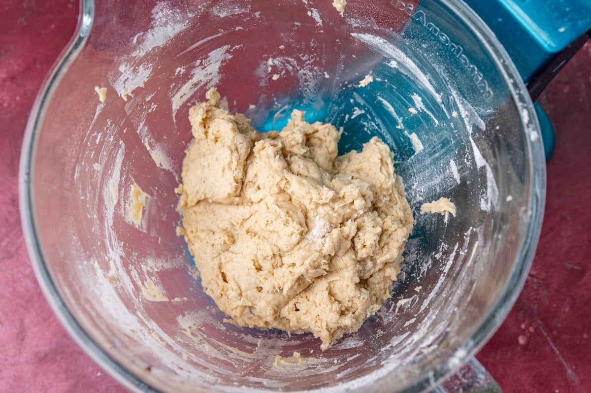 cinnamon roll dough in a glass bowl before kneading