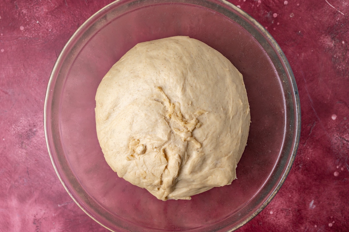 risen cinnamon roll dough in a bowl