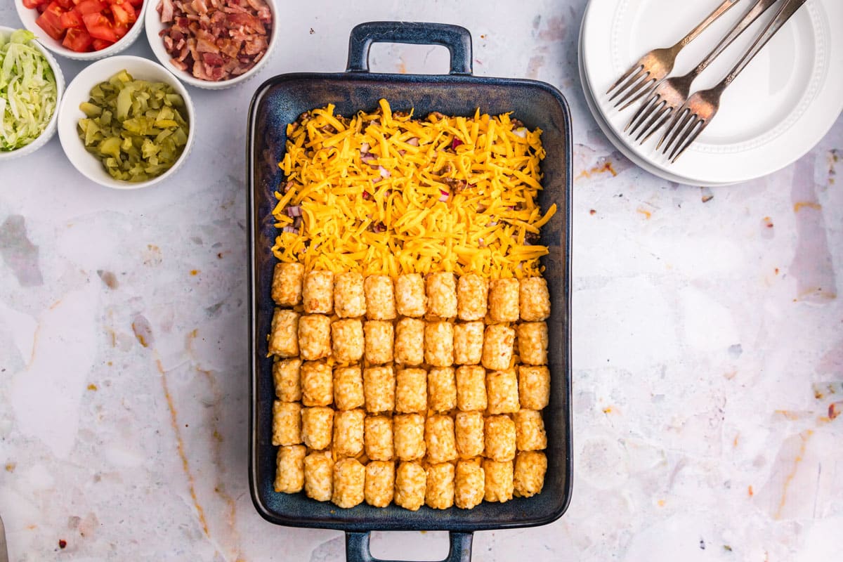 tater tots over ground beef and cheese in a casserole