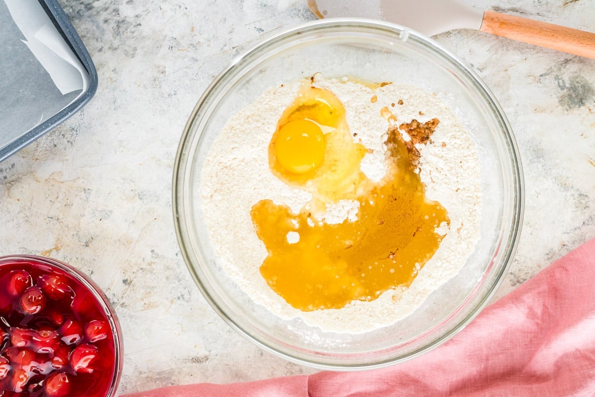 wet ingredients over dry ingredients in a glass bowl