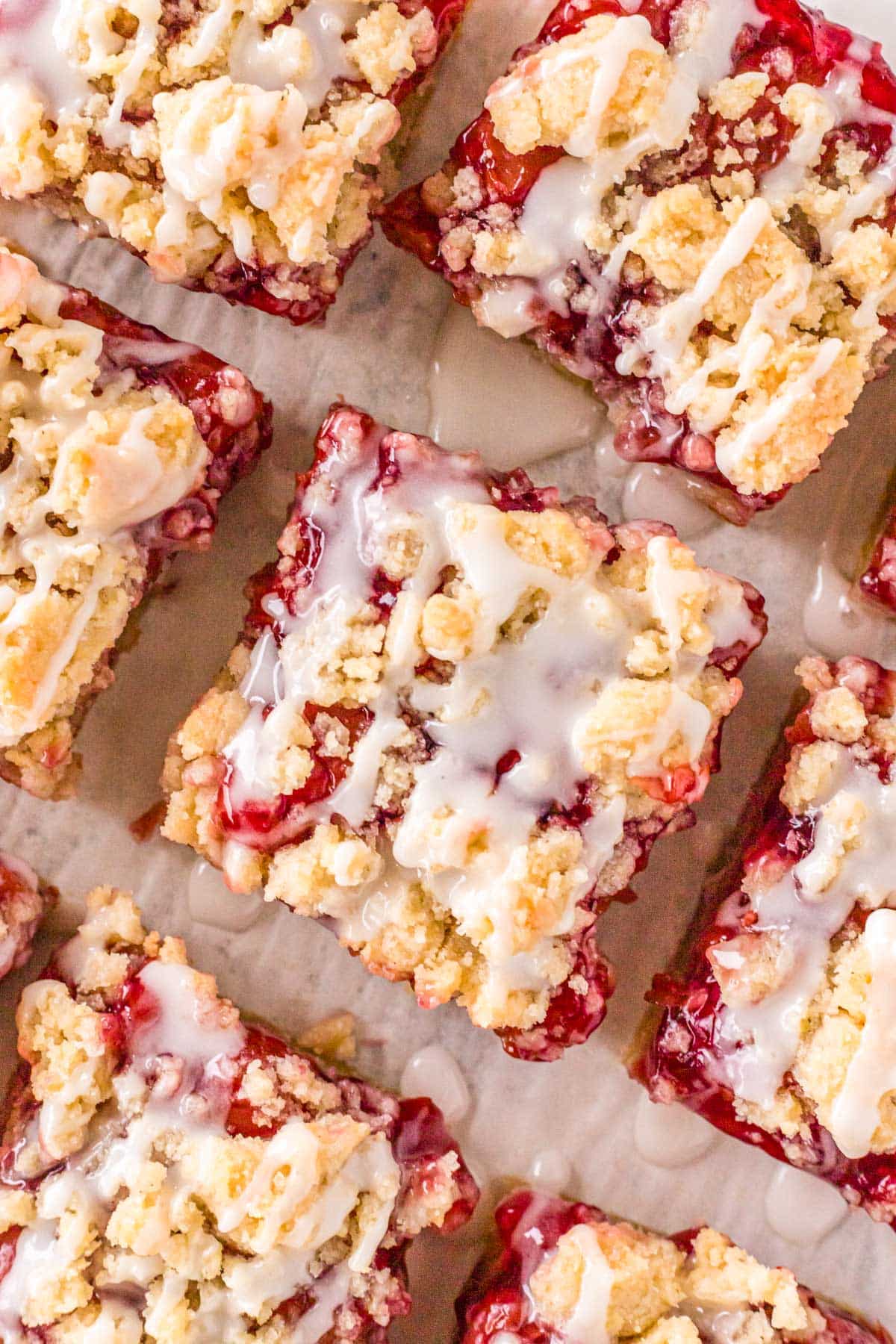 overhead view of streusel topped cherry pie bars on parchment paper