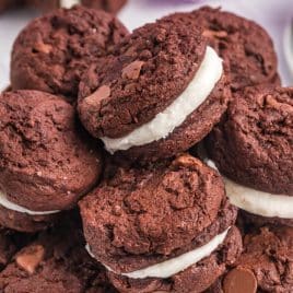 a plate full of chocolate sandwich cookies with buttercream filling