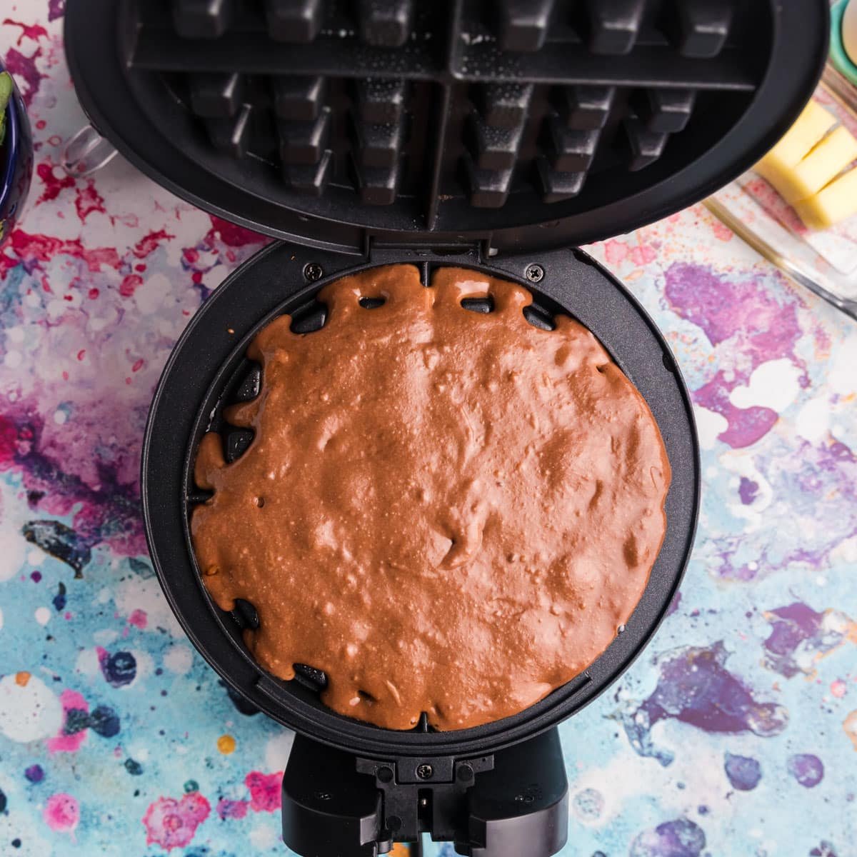 chocolate waffle batter in a waffle iron