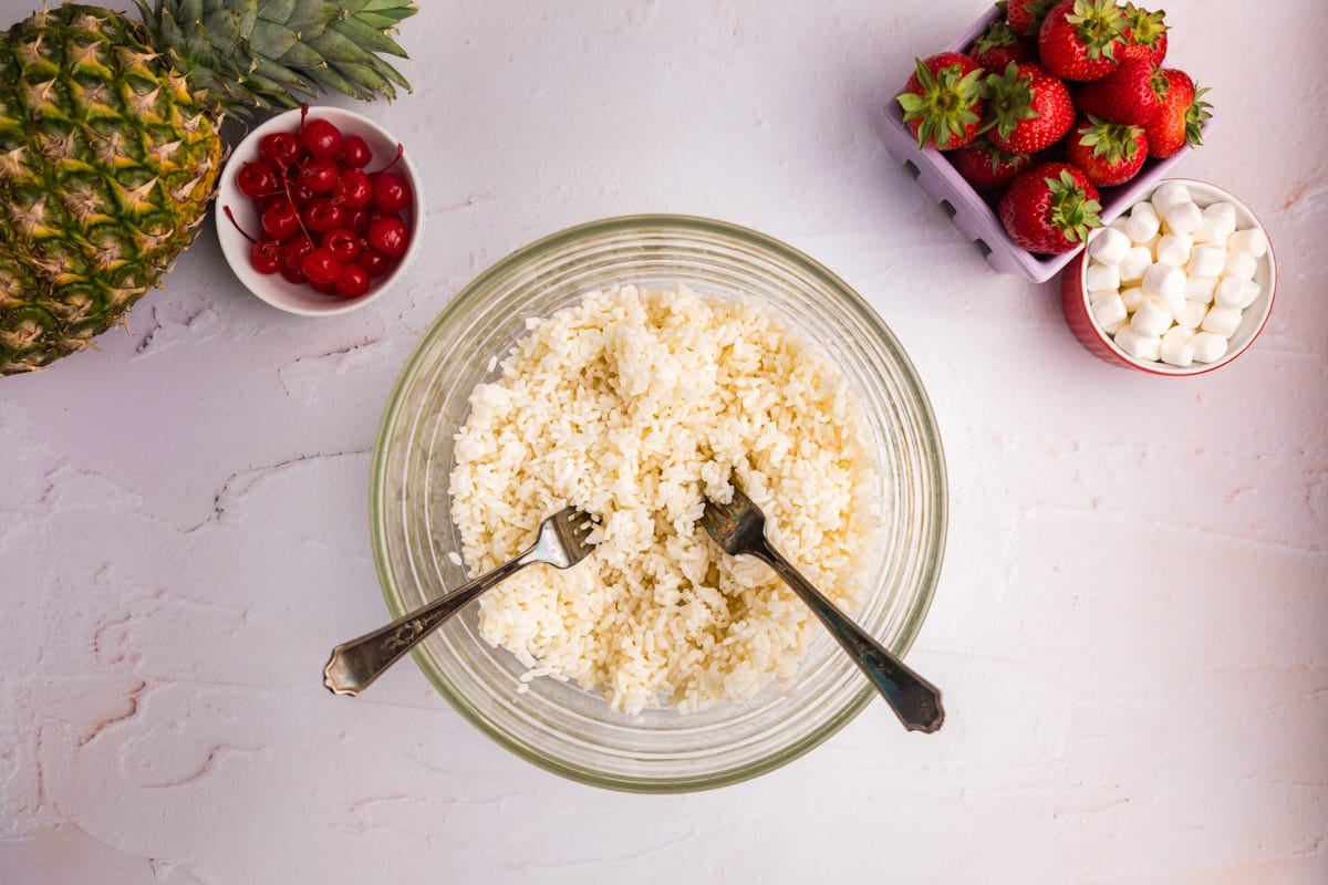 cooked rice and two forks in a glass bowl