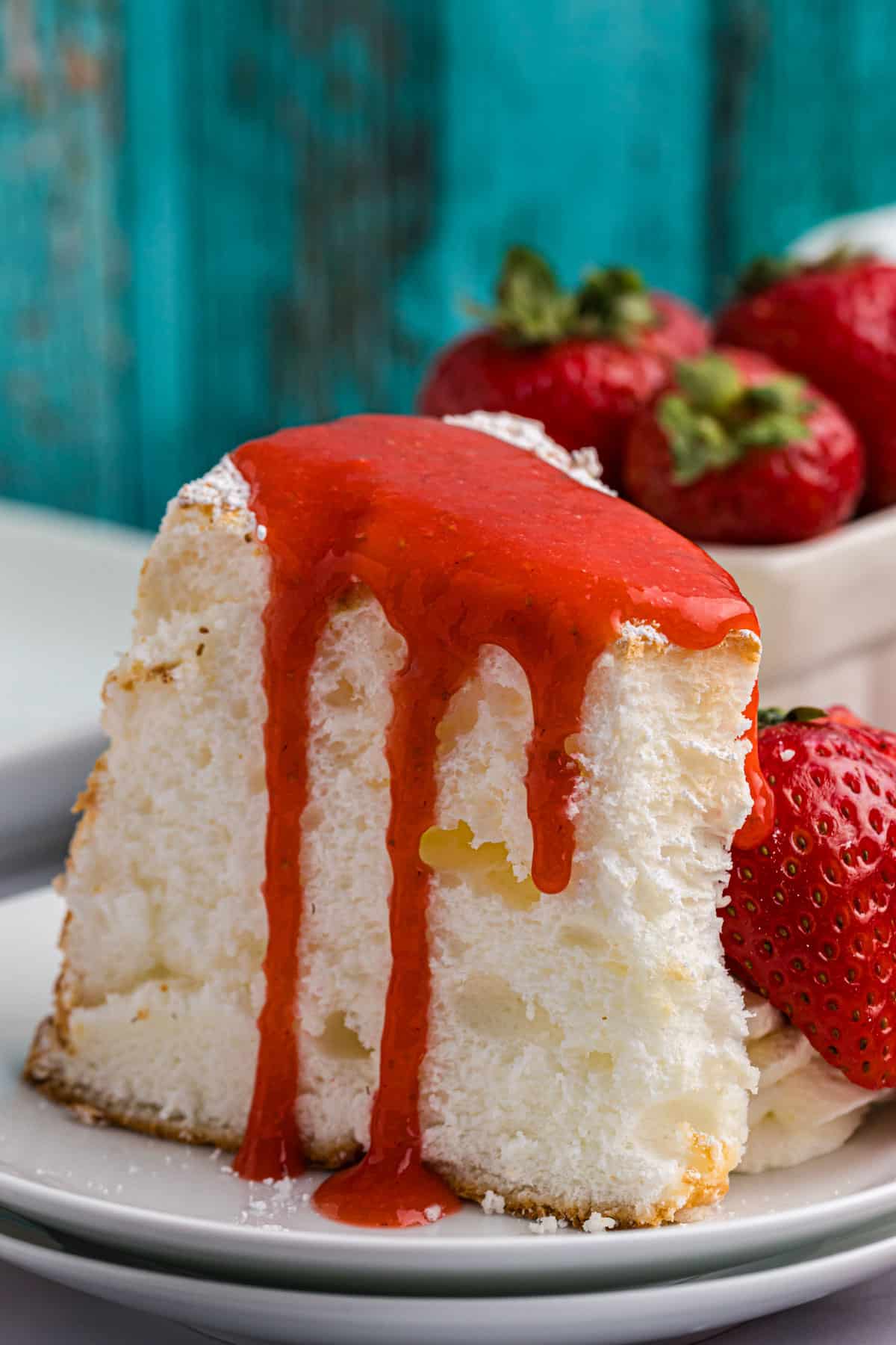 a piece of angel food cake on a plate with strawberry topping