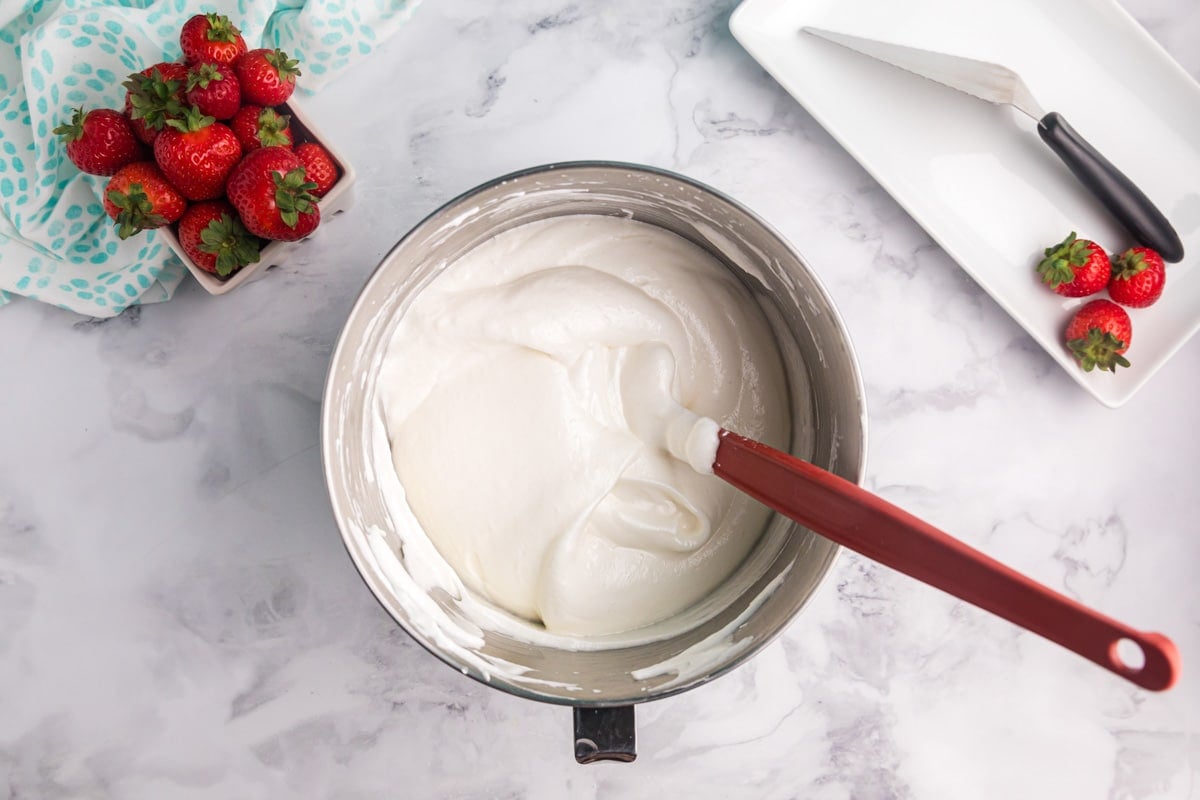 angel food cake batter in a mixing bowl with a spatula