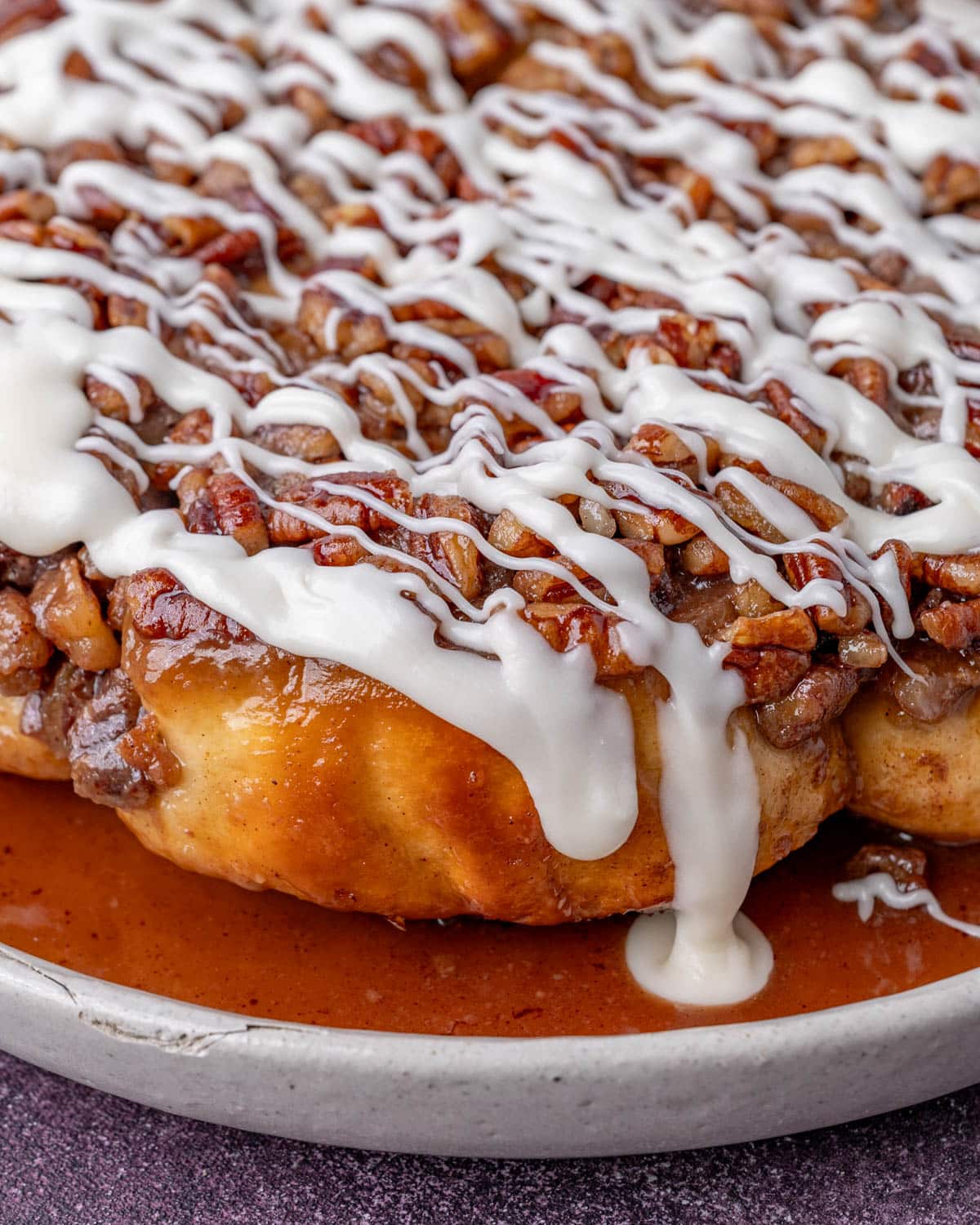 maple pecan sticky buns on a plate with maple glaze