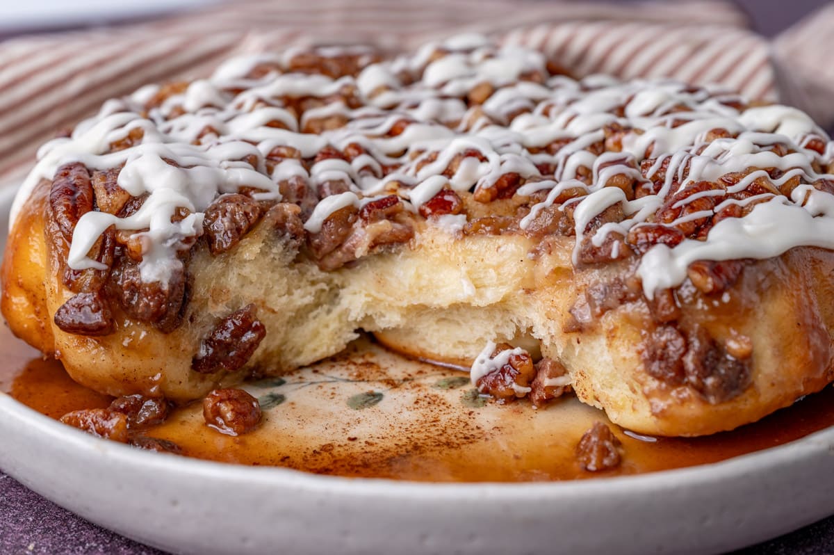 mape pecan sticky buns on a plate with two missing