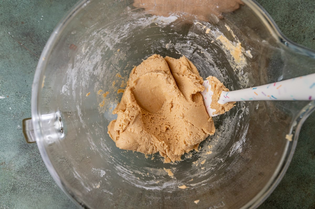 peanut butter cookie dough in a glass bowl with a spatula