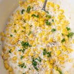 creamed corn in a slow cooker with a spoon
