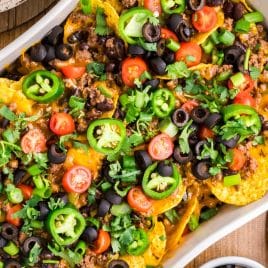 overhead view of a pan of baked beef nachos with fresh toppings