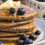 a stack of buckwheat pancakes with blueberries and syrup