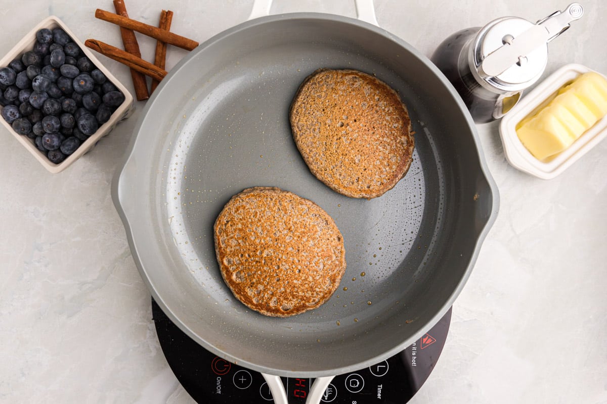 two buckwheat pancakes in a skillet