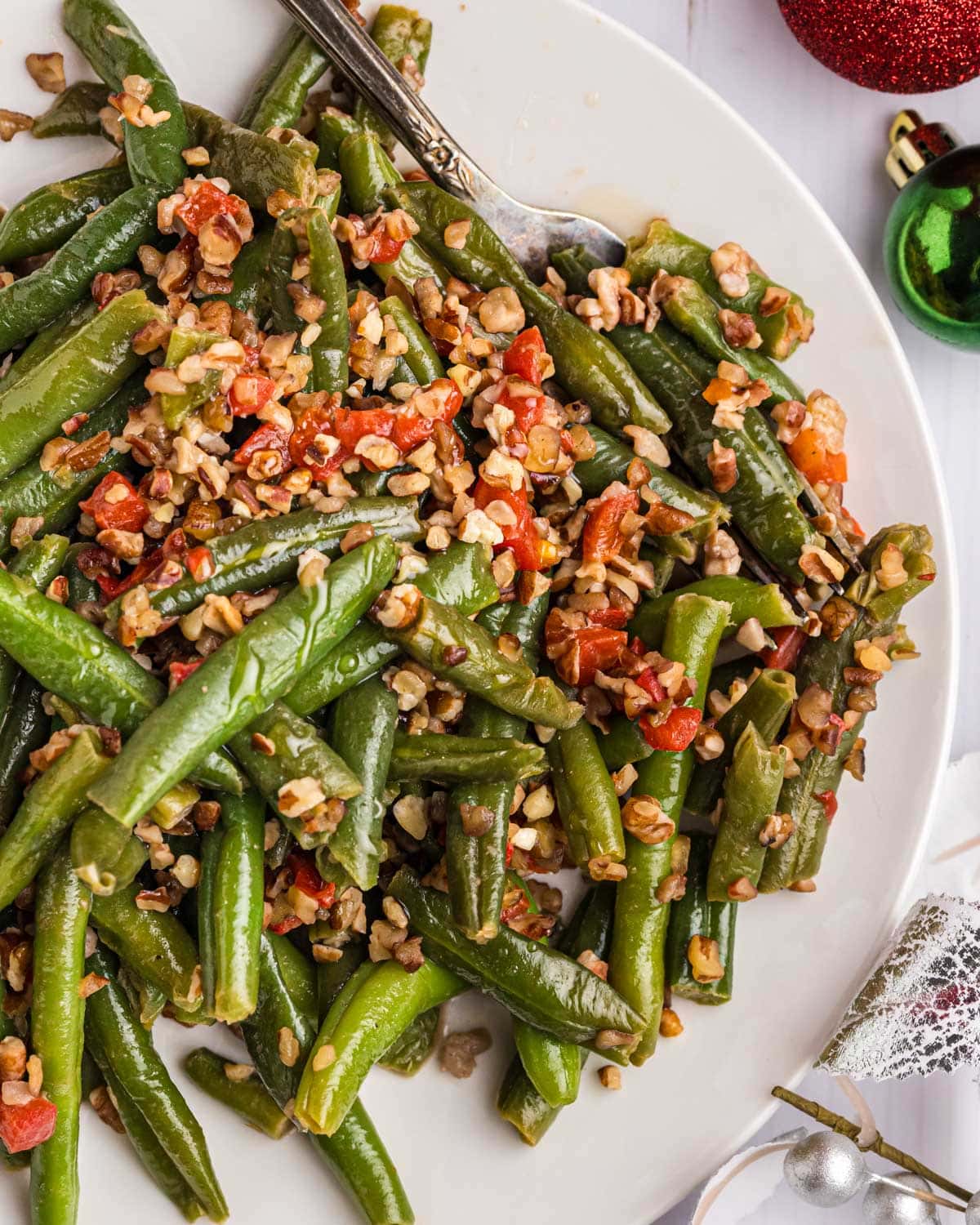 overhead view of a plate of Christmas green beans with toasted pecans