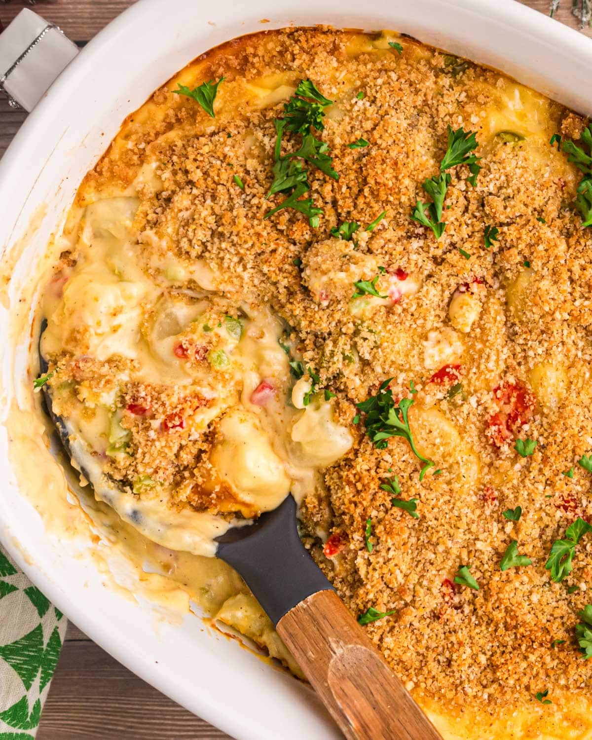 overhead view of christmas cheesy potatoes in a baking pan with a spoon