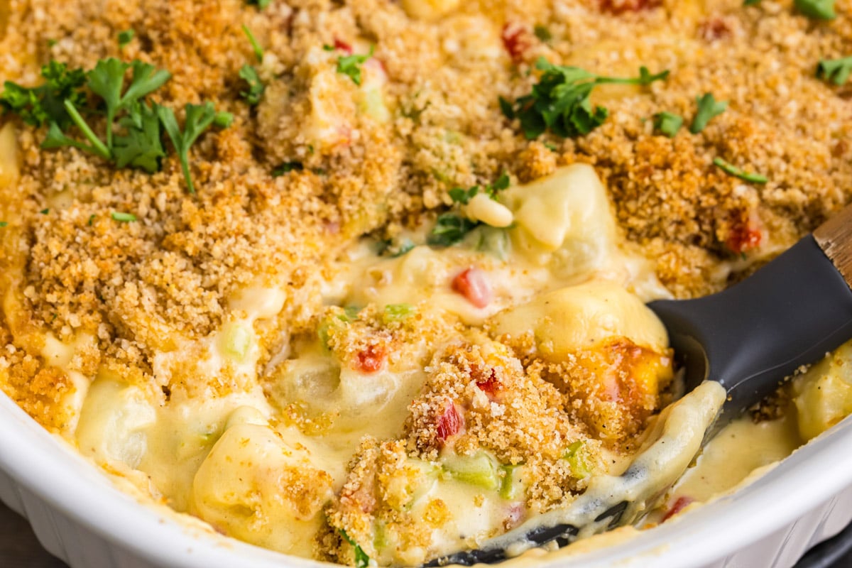 casserole of cheesy christmas potatoes with a spoon