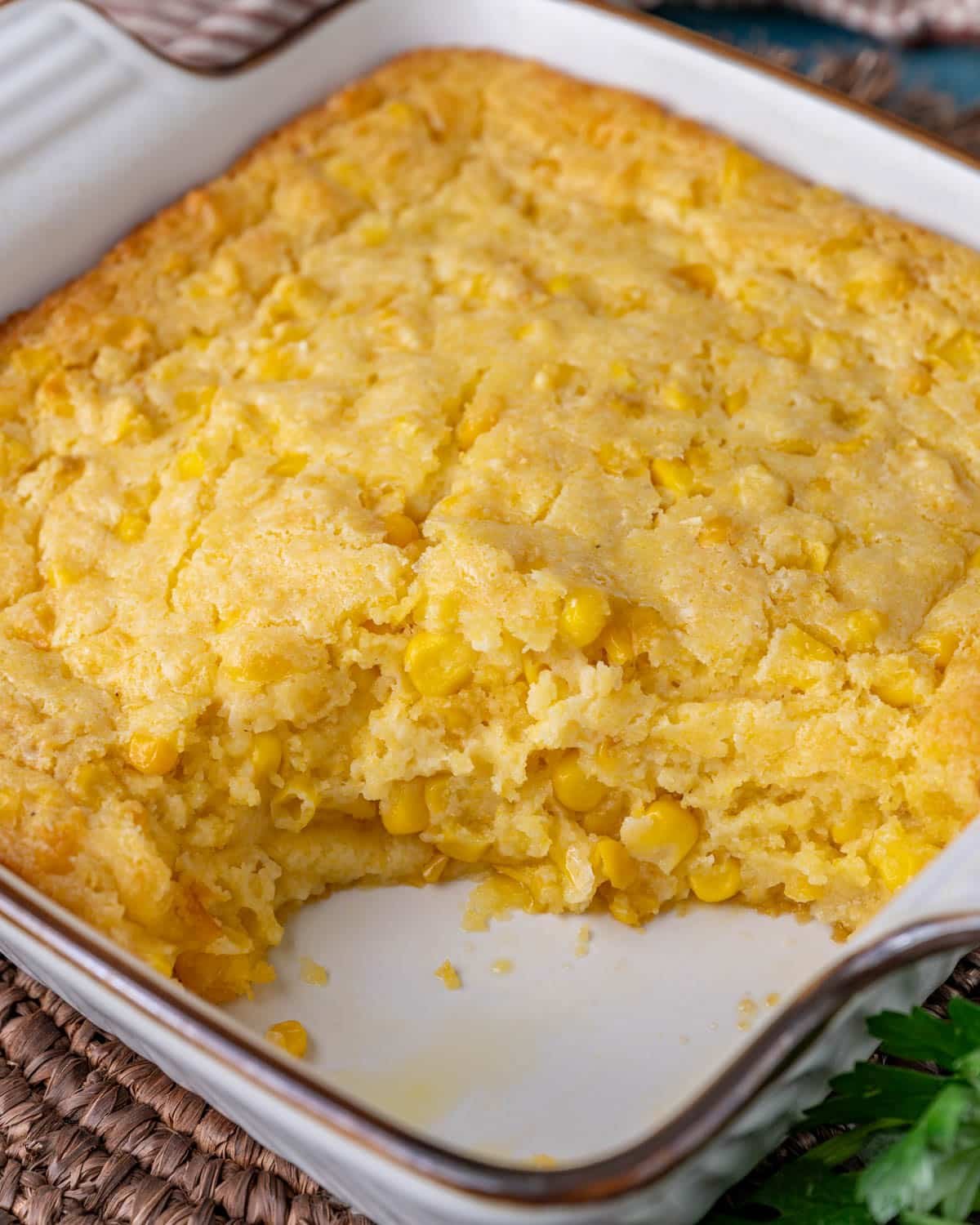 corn casserole in a baking dish with one serving missing