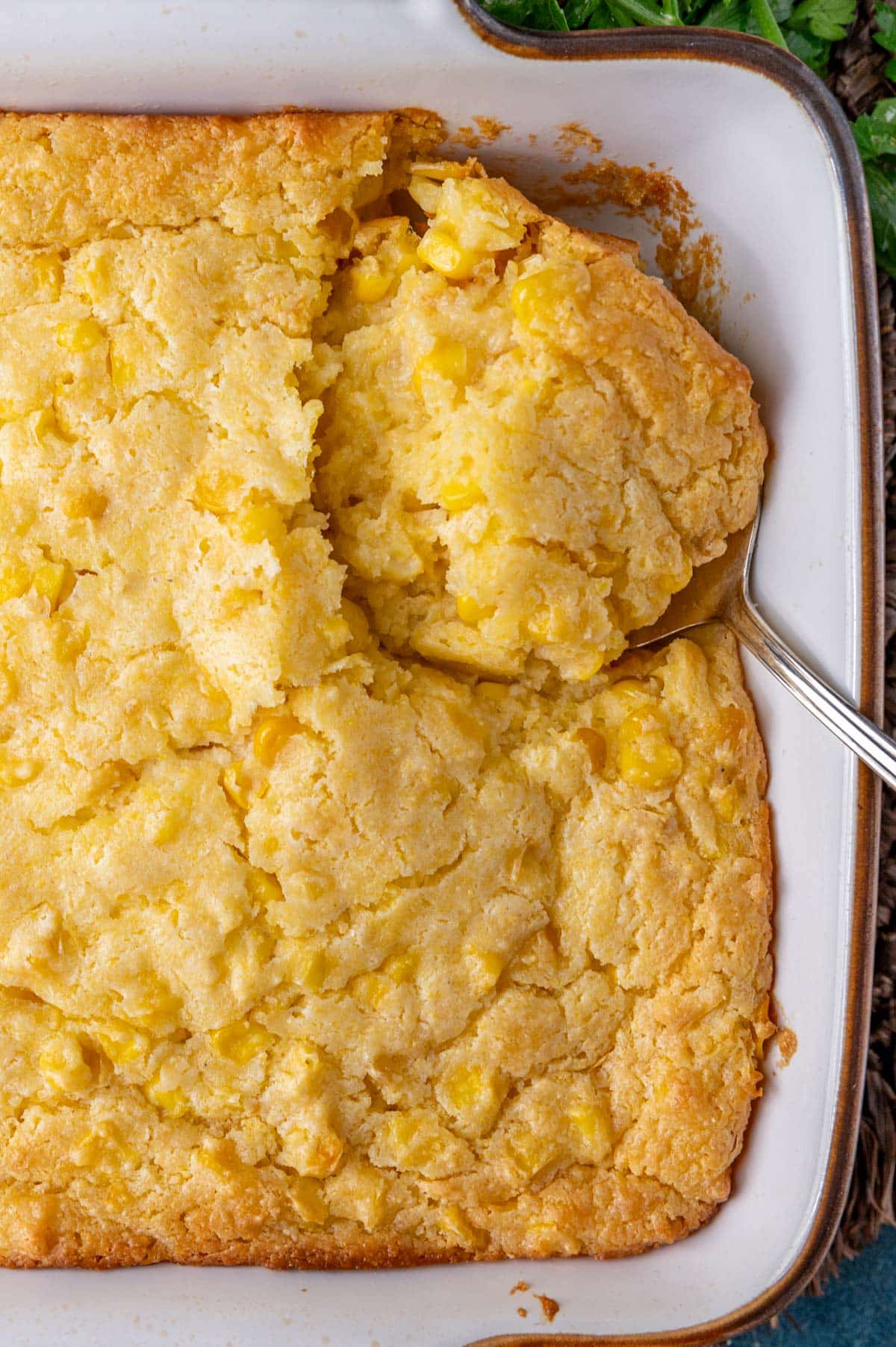corn casserole in a baking pan with a spoon