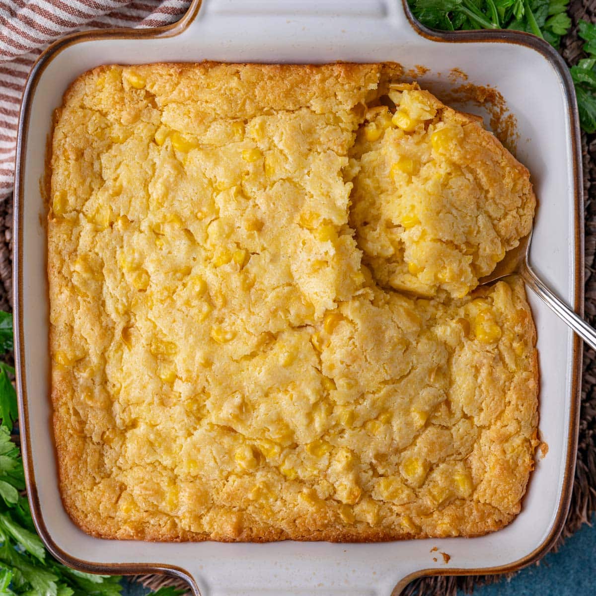 corn casserole in a baking pan with a spoon