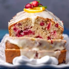 a sliced loaf of cranberry orange bread with glaze