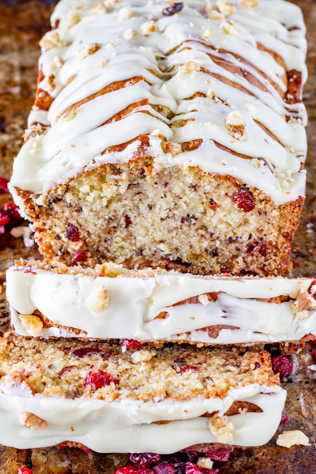 a loaf of cranberry pecan bread with white chocolate glaze