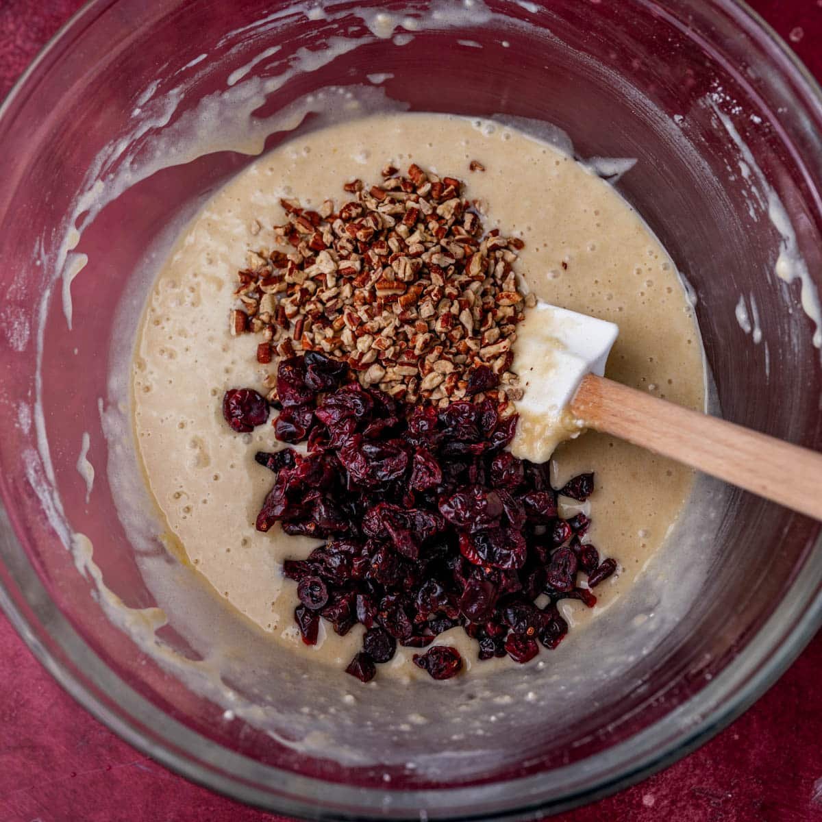 quick bread batter with dried cranberries and pecans on top