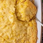 corn casserole in a baking pan with a spoon