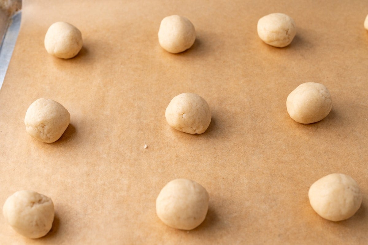 sugar cookie dough balls on a baking sheet